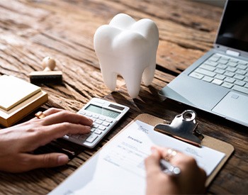 Patient calculating cost on desk with computer
