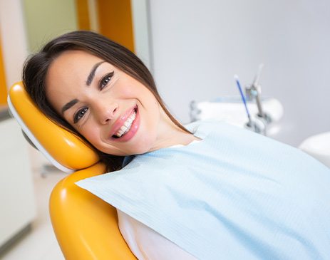 Woman smiling while sitting in treatment chair