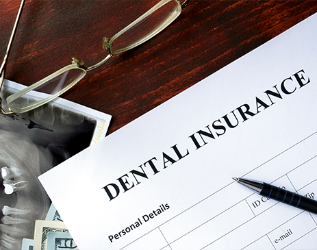 Dental insurance form, pen, glasses, and X-ray