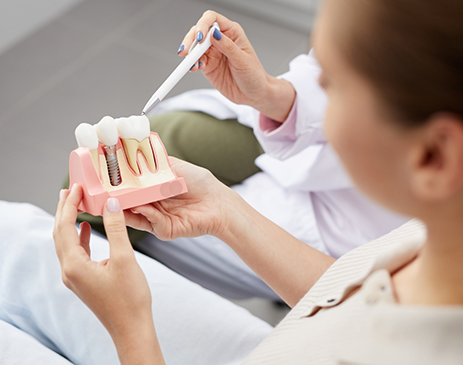 Dental patient looking at model of dental implant