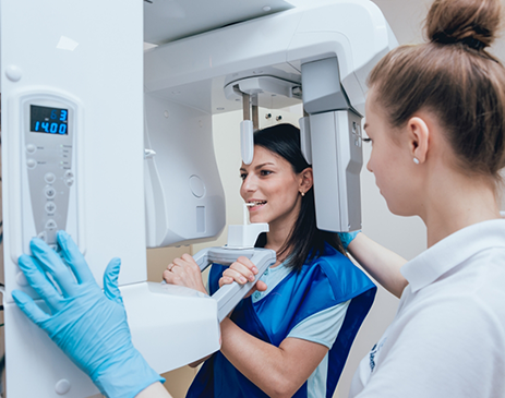 Female patient about to have teeth scanned with cone beam scanner