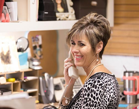 Woman in leopard-patterned shirt talking on phone