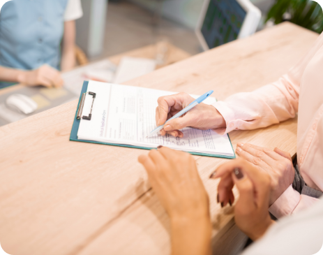 Close up of patient filling out form on clipboard