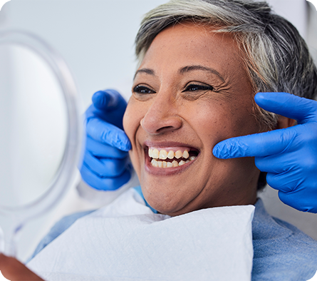 Senior woman checking smile in mirror