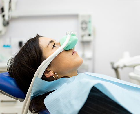 Boy sitting back in dental chair with mask over nose