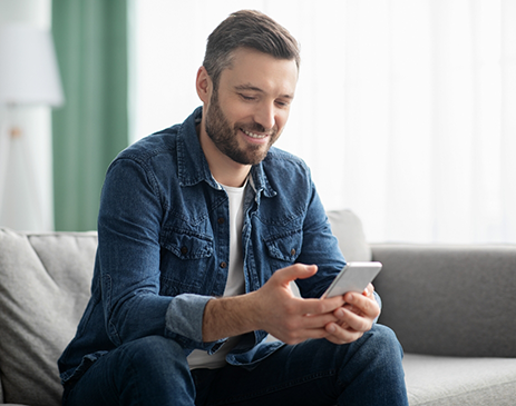 Man sitting on couch and typing on phone