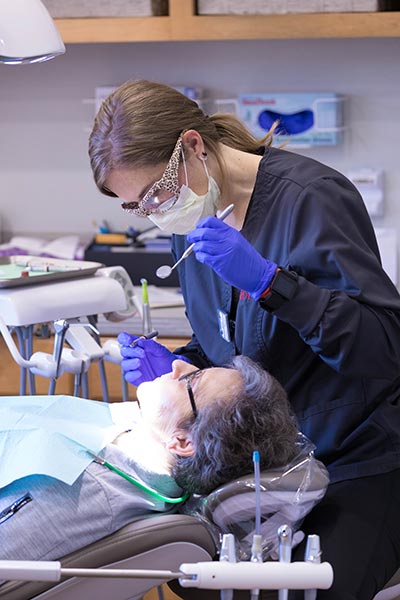 Hygenist at Harper Dental inspecting a patient's teeth in Fort Smith, AR