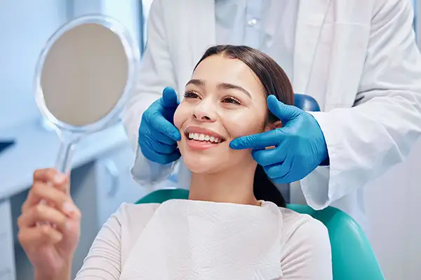 Smiling dental patient looking into mirror after wisdom teeth removal at Harper Dental in Fort Smith, AR